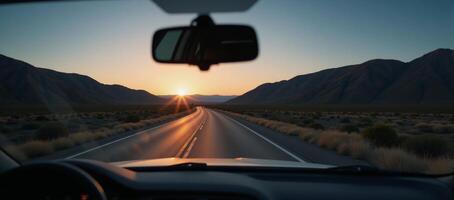 View from a cars rearview mirror featuring the road stretching out behind photo