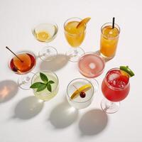 A summery assortment of colorful cocktails on a white backdrop with hard lighting shadow patterns in a topdown perspective photo