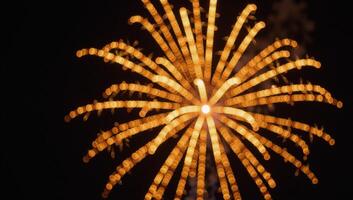 Gold metallic firework display captures vibrant bursts of color against night sky photo