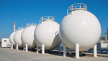 A 3D rendering of a modern petrochemical factory featuring spherical BPVC gas storage tanks under a bright blue sky photo