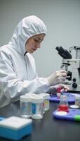 A scientist conducts research in a sterile lab environment while carefully mixing chemicals photo