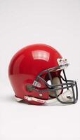Red American football helmet against plain white backdrop photo