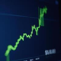 A dynamic stock market graph shows financial growth and investment success depicted as a green upward line against a dark blue background photo