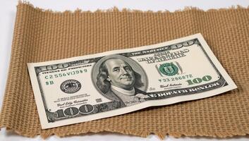 Dollar bills stacked on burlap evoking themes of bribes or bonuses photo