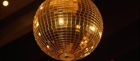 A golden disco ball adds an elegant shimmery radiance to party settings photo