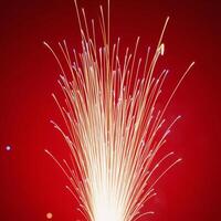 Fireworks illuminate against a striking red backdrop photo