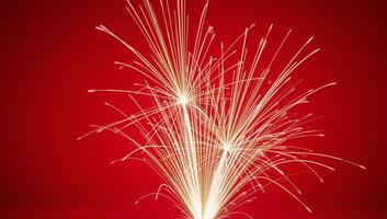 Fireworks illuminate against a striking red backdrop photo