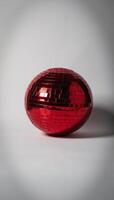 Isolated red disco ball glows against blank canvas backdrop photo