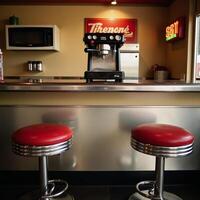 A retro diner counter featuring coffee maker and stools photo