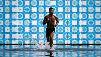 Man runs amidst dotfilled background portrayed as if submerged in water photo