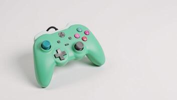Retrostyled game controller with colorful pastel greenpink case is depicted on a clean white backdrop photo