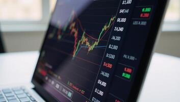 A laptop screen displays a stock market graph with financial data related to trading and investments photo