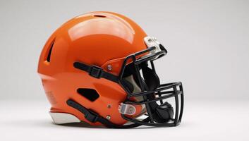 Bright orange American football helmet with black face guard highlighted against clean white backdrop photo