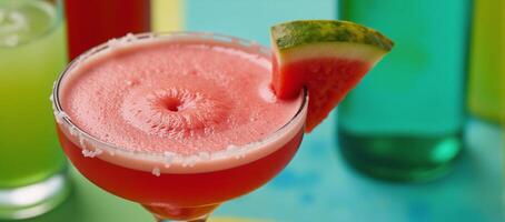 A vibrant closeup image of a red margarita adorned with a watermelon slice against a backdrop of other colorful cocktails set on a festive multicolored tablecloth during a lively party scene photo