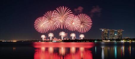 Fireworks display illuminating city skyline at night over water reflection photo