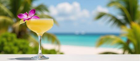 Tropical scene showcasing a yellow margarita with an orchid and lime garnish photo
