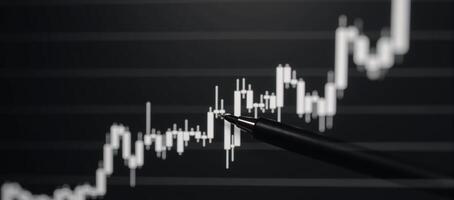 Uptrend line graph candlesticks displayed on an abstract finance chart with BW backdrop photo