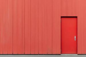 A red door is open on a wall photo