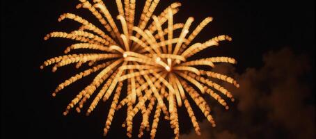 Gold metallic firework display captures vibrant bursts of color against night sky photo