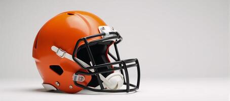 Bright orange American football helmet with black face guard highlighted against clean white backdrop photo