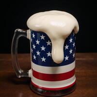 An Americanflagged beer mug overflowing with frothy head photo