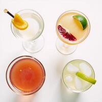 Cocktail shots against a simple white backdrop viewed from above photo