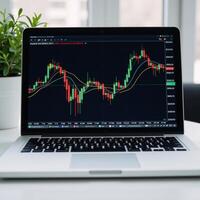 A laptop screen displays a stock market graph with financial data related to trading and investments photo