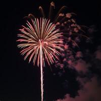 Nighttime firework explosion over a 4th of July themed backdrop photo