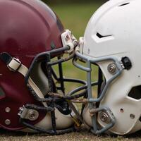 Two clashing helmets locked in an intense moment of impact showcasing sweat and dirt suspended photo