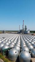Spherical tanks at an industrial factory amidst containers and set against a clear blue sky depicting the exterior view of a chemical manufacturing facility with round storage tanks photo