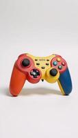 Colorful retro game controller against minimal white backdrop photo