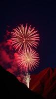 Vibrant firework display lights up mountainous landscape during a lively festival photo