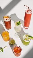 A summery assortment of colorful cocktails on a white backdrop with hard lighting shadow patterns in a topdown perspective photo