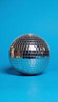 A vibrant disco ball illuminates a lively festive scene with its sparkles against a backdrop of deep blues photo