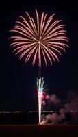 A striking shot showcasing a brightly glowing starburst from exploding fireworks against a dark backdrop at night photo