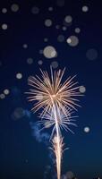 Dark blue sky illuminated by goldenblue fireworks bursts with bokeh light effects photo