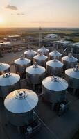 A summer evening industrial scene features a chemical factory with large pressurized hydrogen storage tanks and BPVC manufacturing facilities amidst the sprawling terrain of industrial ASME tanks photo