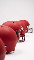 Mediumshot image featuring red American football helmets against a white backdrop photo