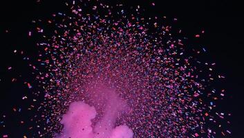 Multicolored nighttime festivity with flying confetti against a dark backdrop photo
