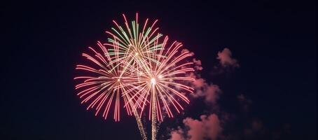 Night sky showcases a vibrant Fourth of July firework display over a bustling cityscape backdrop photo