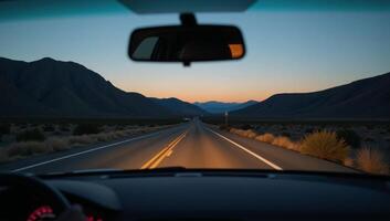 View from a cars rearview mirror featuring the road stretching out behind photo