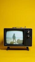 Old television on yellow background photo