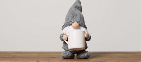 Adorable gnome figurine grayclad mugholding stands on wooded surface photo