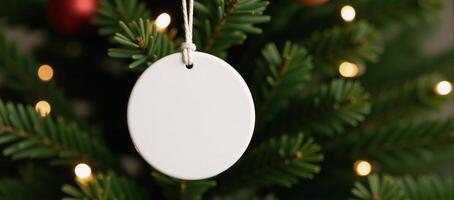 White ceramic circle ornament hanging on Christmas tree photo