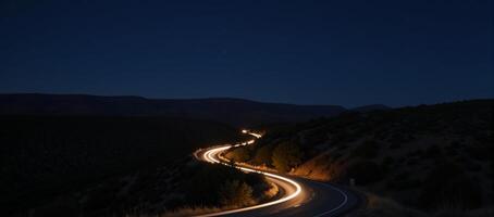 A twilight road with headlightlit curves set amidst a starry night sky photo