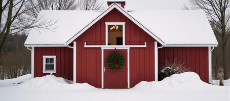 Snowcovered rustic red barn adorned with a holiday wreath photo
