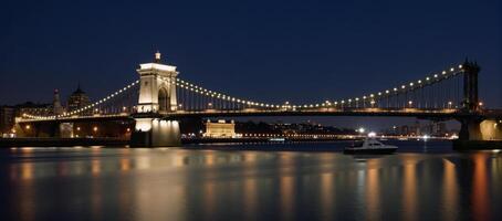 Cityscape featuring iconic bridge at night with shimmering reflections photo
