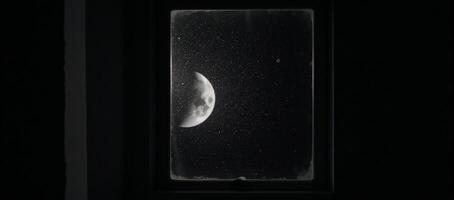 A halfmoon illuminates a dark room from an open window at night photo