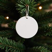 White ceramic circle ornament hanging on Christmas tree photo