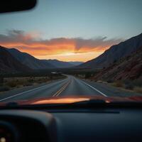 View from a cars rearview mirror featuring the road stretching out behind photo